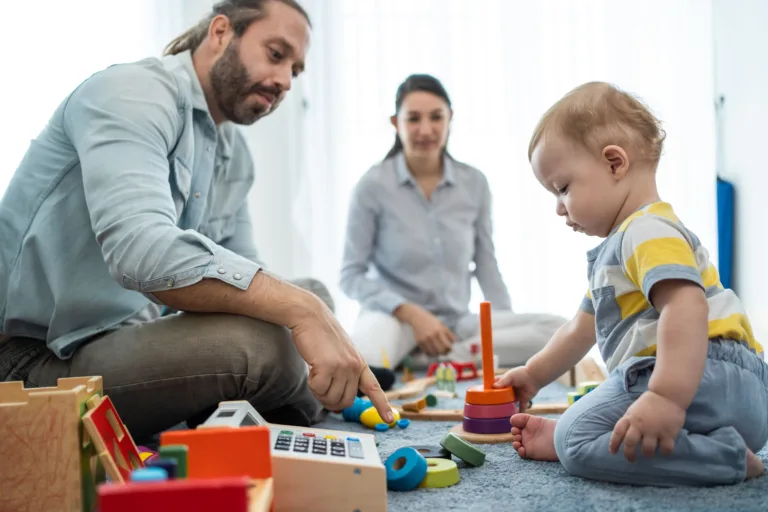 Child playing with educational toys while a caregiver guides learning in a nurturing child care center environment.