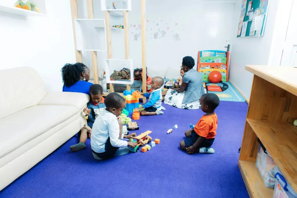 A group of diverse parents participating in interactive parenting workshops at a bright, modern community center in Surrey, BC.