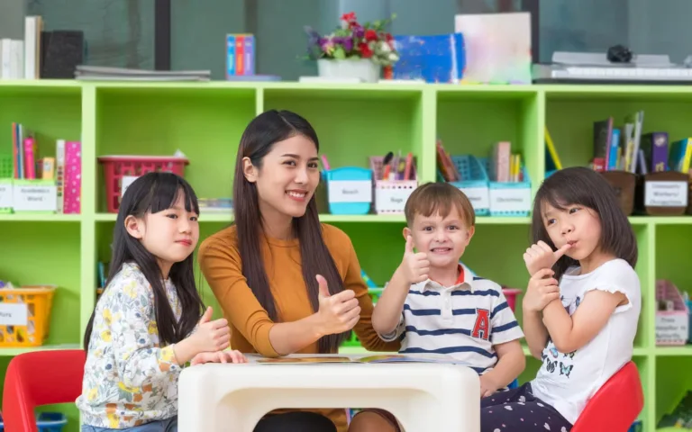 A diverse group of toddlers happily engaged in a guided, play-based learning activity with scoops at a sensory table within a bright, licensed day care in surrey bc.